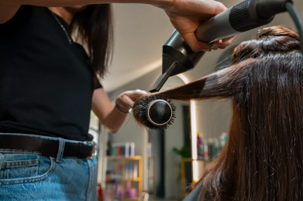 Stylist using a round brush on hair